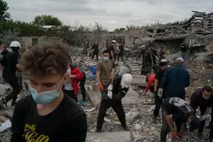 Voluntarios trabajando para limpiar escombros en un lugar donde varias casas fueron destruidas por un ataque ruso contra una zona residencial en Zaporiyia, Ucrania