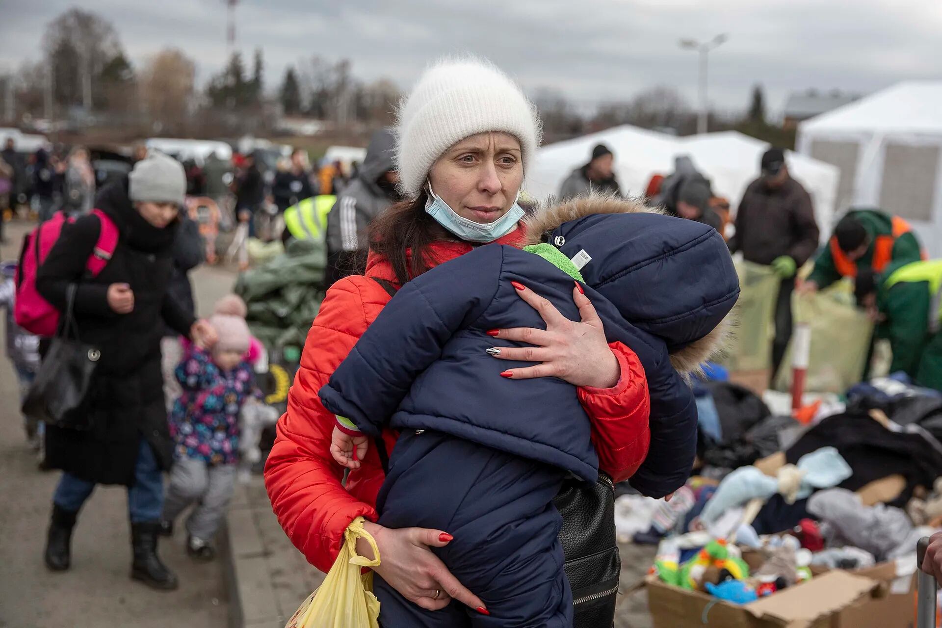 Una mujer sostiene a su hijo al llegar al  cruce fronterizo de Medyka, Polonia; después de huir de Ucrania.
