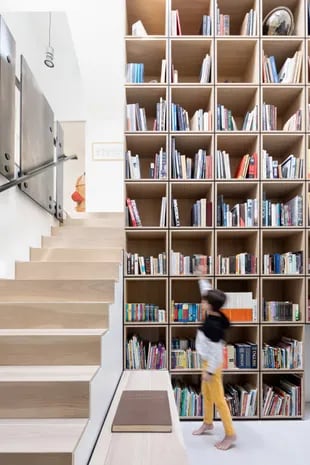 La biblioteca de madera está integrada en la escalera