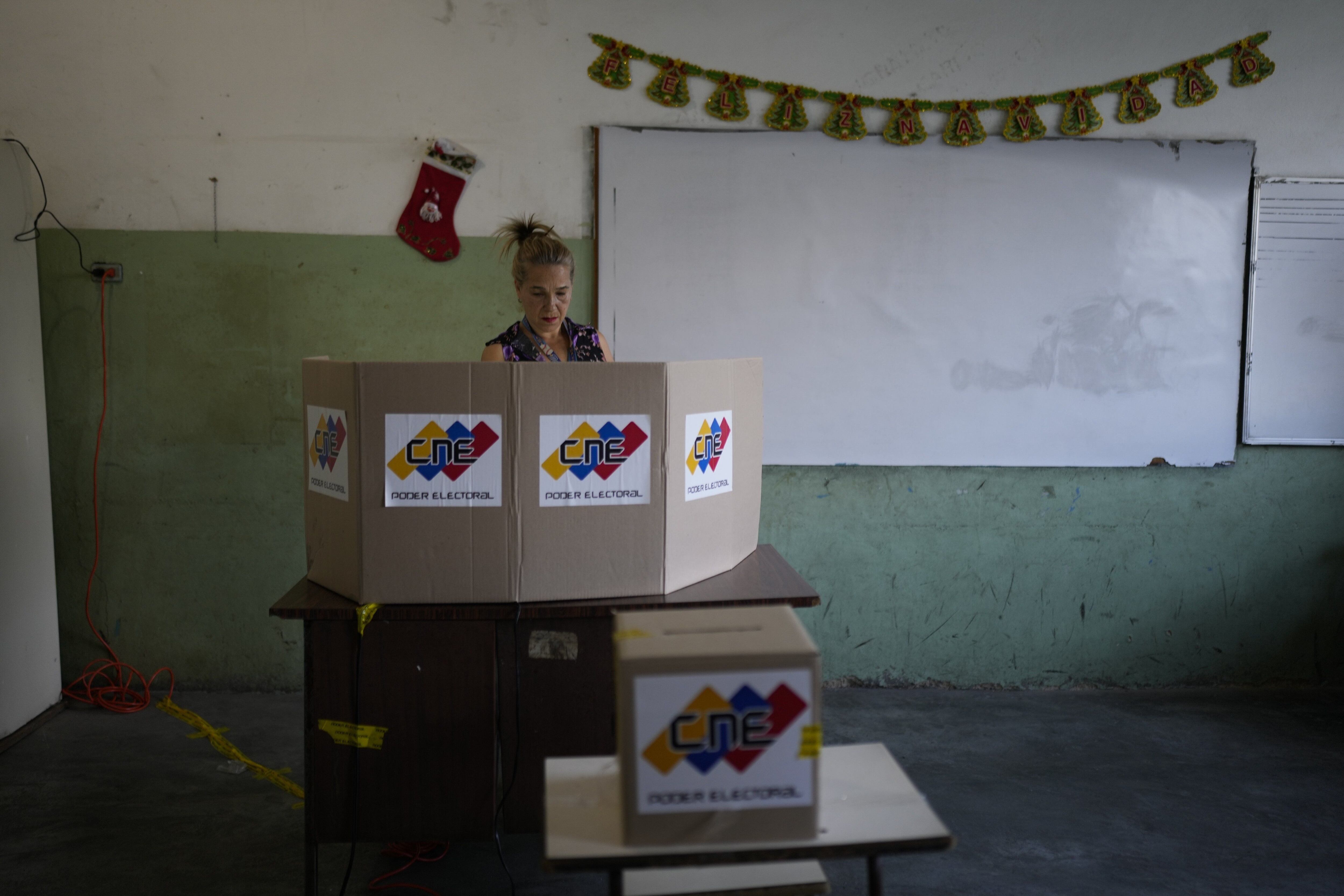 Una mujer vota durante un referéndum sobre el futuro de un territorio en disputa con Guyana, en un colegio electoral en Caracas, Venezuela, el domingo 3 de diciembre de 2023.