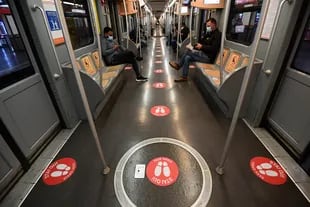 Los autobuses en Milán tienen etiquetas rojas en el piso que marcan la distancia entre los pasajeros en plena pandemia de coronavirus