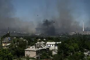 Un edificio dañado es fotografiado en Lysychansk mientras el humo negro y la suciedad se elevan desde la cercana ciudad de Sieverodonetsk durante la batalla entre las tropas rusas y ucranianas en la región oriental ucraniana de Donbass el 9 de junio de 2022.