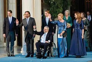 El príncipe Constantino Alexios, el ex rey Constantino y la ex reina Ana María saludan a la gente y a la prensa que los esperaba a la salida.