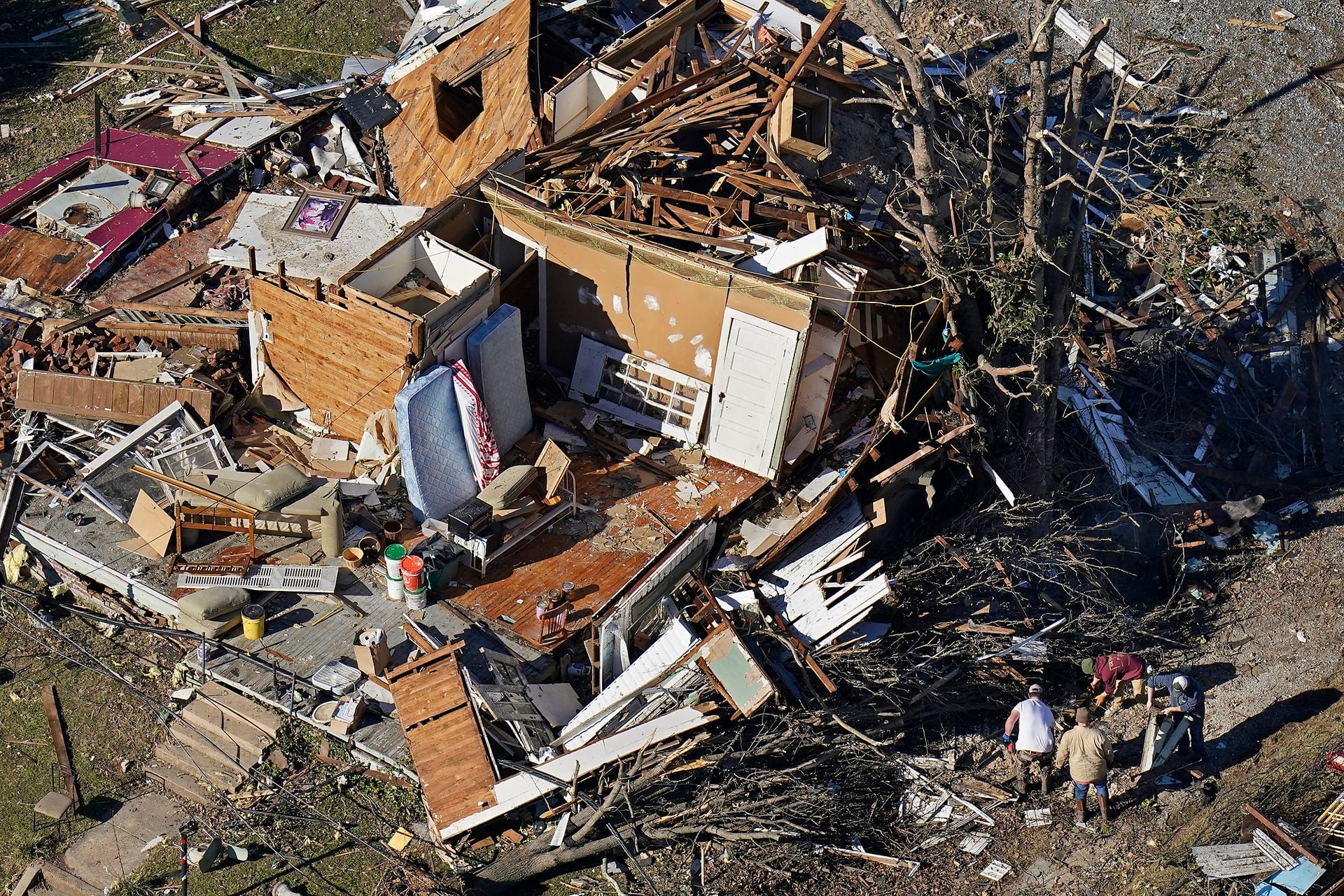  En esta foto aérea, las personas examinan los escombros de una casa destruida después de los tornados que arrasaron la región, en Dresde, Tennessee, el domingo 12 de diciembre de 2021 