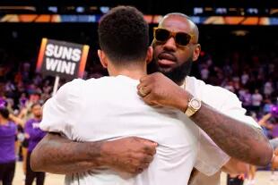 LeBron James, anoche, abrazando a Devin Booker, de los Phoenix Suns.