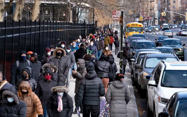 La gente hace fila parasecibe los kits de prueba para detect el COVID-19 points distributeur in el vecindario del Lower East Side in the lointain Manhattan of New York, jueves, 23 décembre 2021