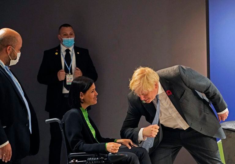 El primer ministro británico, Boris Johnson, saluda a la ministra de Energía de Israel, Karine Elharrar, luego de haber facilitado su acceso al evento