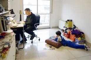 Gonzalo Fuertes, y su hijo Francisco, de 7 años, cada uno con su dispositivo en su casa