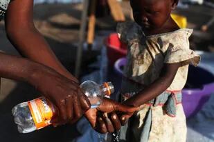 01/06/2014 Una madre lava las manos a su hija para evitar el cólera en Sudán del Sur POLITICA SUR DE SUDÁN INTERNACIONAL AFRICA ANDREEA CAMPEANU/MSF