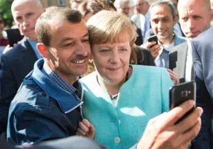 La canciller alemana Angela Merkel se toma una selfie con un refugiado en el centro de recepción de refugiados en Berlín, Alemania, el 10 de septiembre de 2019