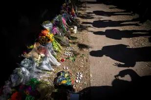 ARCHIVO - Las sombras de los visitantes a un monumento improvisado para las víctimas fatales del concerto Astroworld en Houston, el 7 de noviembre de 2021. (Foto AP/Robert Bumsted, archivo)