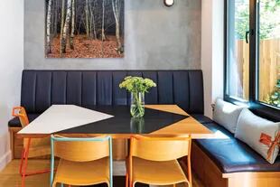 Las arquitectas diseñaron a medida la mesa de roble pintada y los sillones con cajones de guardado y asiento y respaldo en cuero. Sillas ‘Canteen’ (Very Good & Proper) y foto de Dan Perrone.