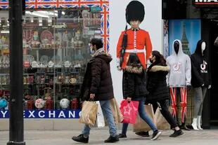Varias personas que llevan bolsas de compras pasan frente a una tienda de souvenirs en Oxford Street en Londres
