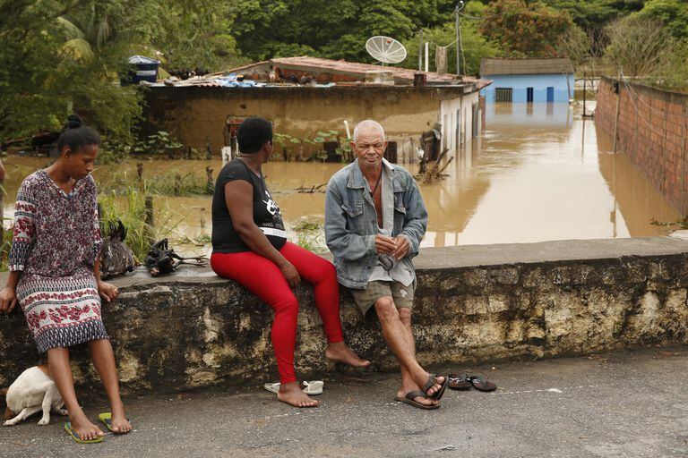 On December 26, 2021, people waited until the water level in a street affected by flooding caused by heavy rains in Idaho, in the province of Bahia in Brazil.