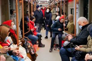 En esta imagen del jueves 24 de febrero de 2022, personas revisan sus teléfonos mientras viajan en el subte de Moscú. (AP Foto/Alexander Zemlianichenko Jr)