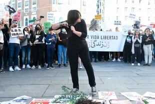 Una chica se corta el pelo, como forma de protesta en la plaza del Callao, en Madrid