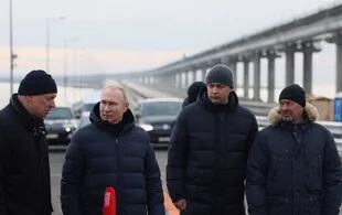 El presidente ruso Vladimir Putin, flanqueado por el viceprimer ministro Marat Khusnullin, visita el puente del estrecho de Kerch, también conocido como puente de Crimea, que fue atacado en octubre por Ucrania 