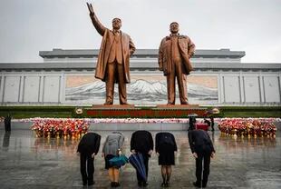 La gente rinde homenaje a las estatuas del fundador de Corea del Norte Kim Il Sung y al líder Kim Jong Il en Pyongyang