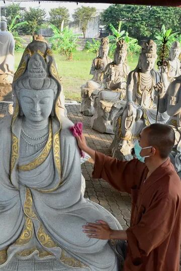 Un sacerdote budista limpia las estatuas de Buda en el templo Vihara Mahavira en Semarang