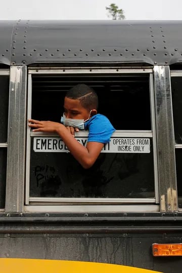 Un joven hondureño que intentaba llegar a Estados Unidos mira por la ventana de un autobús mientras espera volver a casa después de ser enviado de regreso por las autoridades guatemaltecas, en El Florido, Honduras, en la frontera con Guatemala