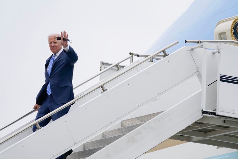 El presidente de Estados Unidos, Joe Biden, saluda mientras baja del Air Force One en el aeropuerto internacional Capital Region, en Lansing, Michigan. (AP Foto/Evan Vucci)
