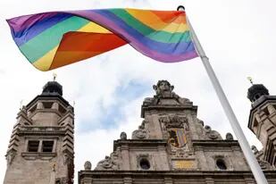 ARCHIVO - Una bandera arcoíris ondea sobre el ayuntamiento en Leipzig, Alemania, 23 de junio de 2021. El ministerio del Interior alemán dijo el miércoles 13 de abril de 2022 que ha autorizado izar la bandera sobre edificios públicos en ciertas ocasiones. (Hendrik Schmidt/dpa via AP, File)