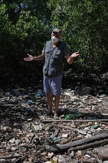 El biólogo Mario Moscatelli, que dirige un programa para replantar bosques de manglares en un antiguo vertedero, muestra basura que ha entrado en un río que desemboca en la Bahía de Guanabara