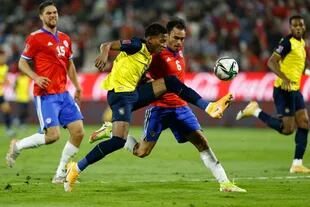 En Santiago, anoche: el ecuatoriano Gonzalo Plata y el chileno Enzo Roco disputan la pelota durante el partido de eliminatorias para Qatar 2022, que terminó con victoria 2-0 de los visitantes.