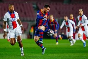 Barcelonas Lionel Messi, right, duels for the balls with PSGs Presnel Kimpembe during the Champions League round of 16, first leg soccer match between FC Barcelona and Paris Saint-Germain at the Camp Nou stadium in Barcelona, Spain, Tuesday, Feb. 16, 2021. (AP Photo/Joan Monfort)