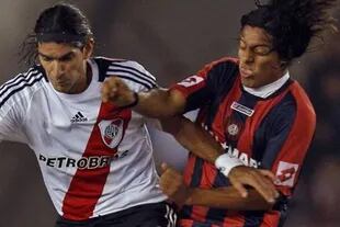 Walter Acevedo disputa la pelota con Sebastián Abreu