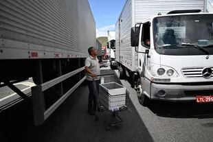 A man sells food to truckers blocking the Via Dutra PR-116 highway between Rio de Janeiro and Sao Paulo on October 31, 2022, in Barra Manza, in the Brazilian state of Rio de Janeiro.