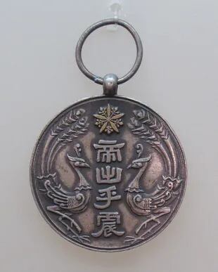 Una medalla conmemorativa de la entronización de Puyi alentada por los ocupadores japoneses.