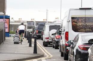 Un turista en bicicleta, cruza con su valija por el puerto de Dover