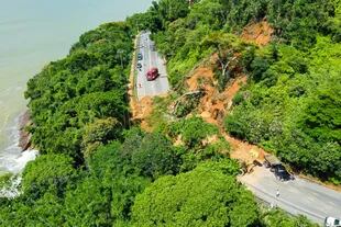 Esta foto difundida por la Defensa Civil de Ubatuba muestra la carretera SP-55 bloqueada por un deslizamiento de tierra en el municipio de Ubatuba, costa norte del estado de Sao Paulo, Brasil, el 19 de febrero de 2023. 