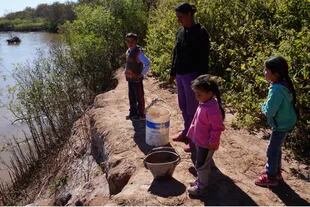 Ema Erén va con tres de sus cinco hijos a juntar agua del río.