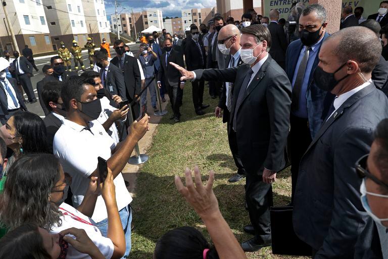 Bolsonaro saluda tras una ceremonia de un programa de casas para gente sin vivienda, a comienzos de abril