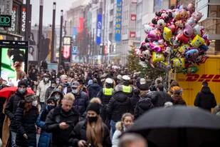A pesar del tiempo lluvioso, el centro de la ciudad de Duesseldorf, Alemania, luce muy concurrido a pesar de las reglas existentes contra el COVID-19 para los minoristas, poco antes de Navidad, el sábado 18 de diciembre de 2021. (Malte Krudewig /dpa vía AP)