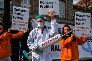 Un activista muestra una jeringa gigante con la palabra "Solidaridad" durante una manifestación frente al Ministerio de Economía en Berlín el 10 de marzo de 2021, para pedir la restricción de las patentes de las vacunas contra el coronavirus para que puedan producirse en todo el mundo