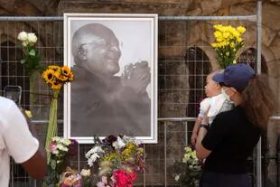 La gente lleva flores a la Catedral de St. Georges, donde se instaló un Muro en Recuerdo de Desmond Tutu, Premio Nobel de la Paz, después de la noticia de su muerte, el 26 de diciembre de 2021 en Ciudad del Cabo. 