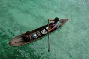 Niños de Bajau Laut en un bote, en Indonesia