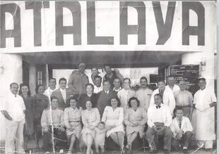 Empleados y familiares posan junto a la entrada principal en una foto tomada en la década de 1940