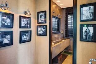 Un hall entelado con más fotos familares antecede a un baño, un oasis con espejo de agua incluído.