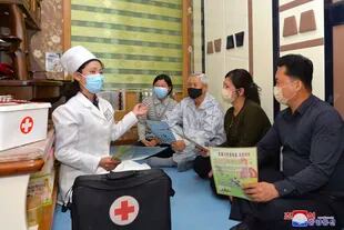 En esta foto proporcionada por el gobierno de Corea del Norte, un médico visita a una familia durante una actividad para el público sobre las medidas de prevención del COVID-19, en Pyongyang, Corea del Norte, el martes 17 de mayo de 2022.