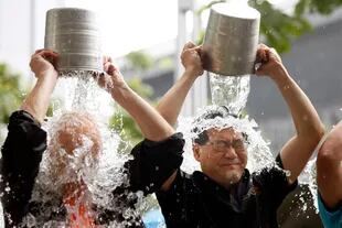 El viral del balde de agua helada llegó a todo el mundo; en la foto, dos ejecutivos de Hong Kong se suman al desafío