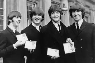 Ringo Starr, John Lennon, Paul McCartney y George Harrison muestran sus medallas de Miembro de la Orden del Imperio Británico entregadas por la reina Isabel II, el 26 de octubre de 1965