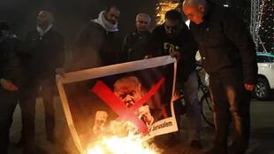 Palestinos queman un cartel con la imagen de Donald Trump
