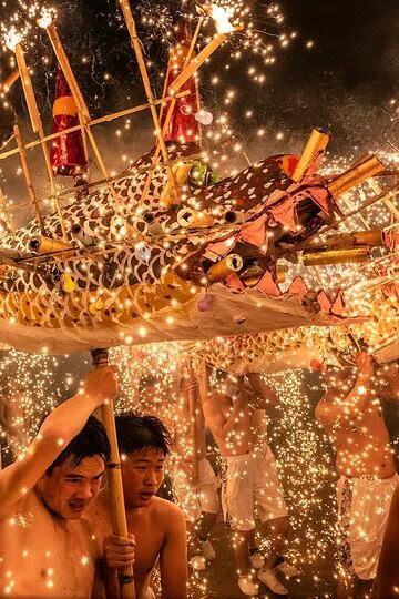 Elección de la gente, Categoría Gente, la imagen es de Léo Kwok, varias personas en Meizhou, China, realiza una danza del dragón de fuego, bañada por chispas de hierro fundido que arrojan fuegos artificiales para celebrar el Festival de los Faroles