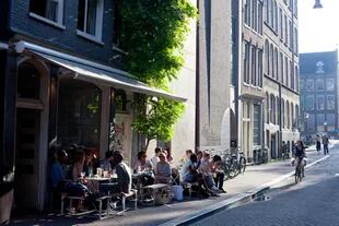Aún en la propia ciudad se pueden disfrutar pequeños placeres, como un café o un paseo como se aprecia con estos vecinos de Ámsterdam