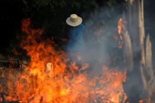 Un granjero camina entre las llamas que afectan a gran parte del Amazonas