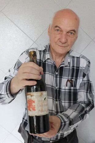 Luis Álvarez Nani, único descendiente vivo de los Nani, muestra una botella de la confitería de su abuelo.